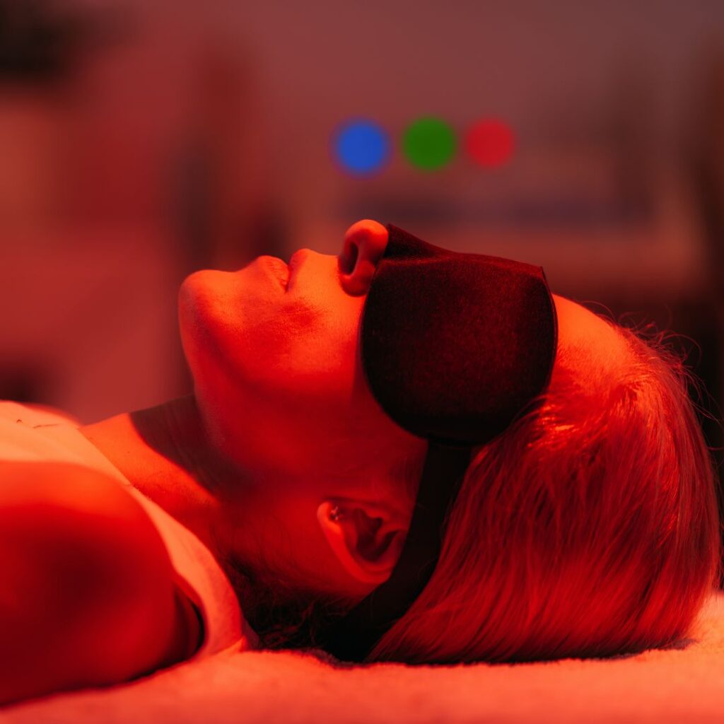 woman in eye mask under red light lamp