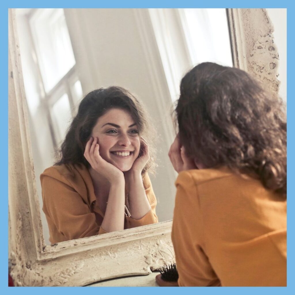 woman looking at face in mirror